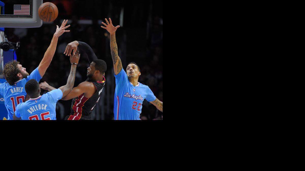 
Dwyane Wade, del Heat, pasa la bola sobre tres rivales, el domingo en Los Angeles contra los Clippers.

