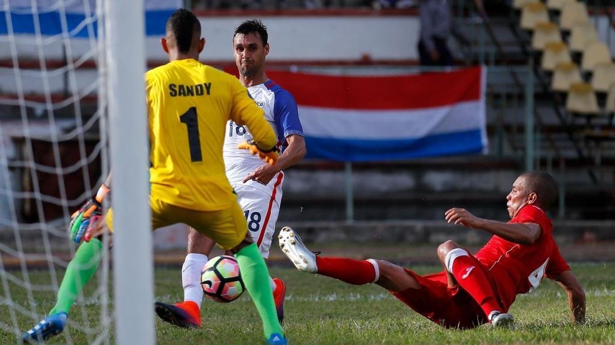 Chris Wondolowski (c), de EEUU, da un pase de gol a Julian Green (no aparece en la foto), entre el arquero Sandy Sánchez (1)y Yasmani López, de Cuba, en el Estadio Pedro Marrero, el viernes 7 de octubre.