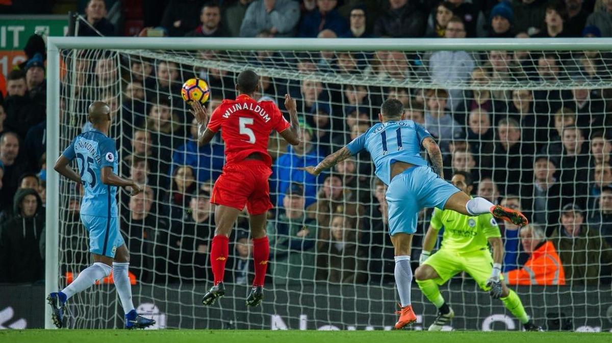 Georginio Wijnaldum (5), del Liverpool, anota de cabeza, el sábado. Fernandinho y Aleksandar Kolarov, del Man City, llegan tarde.