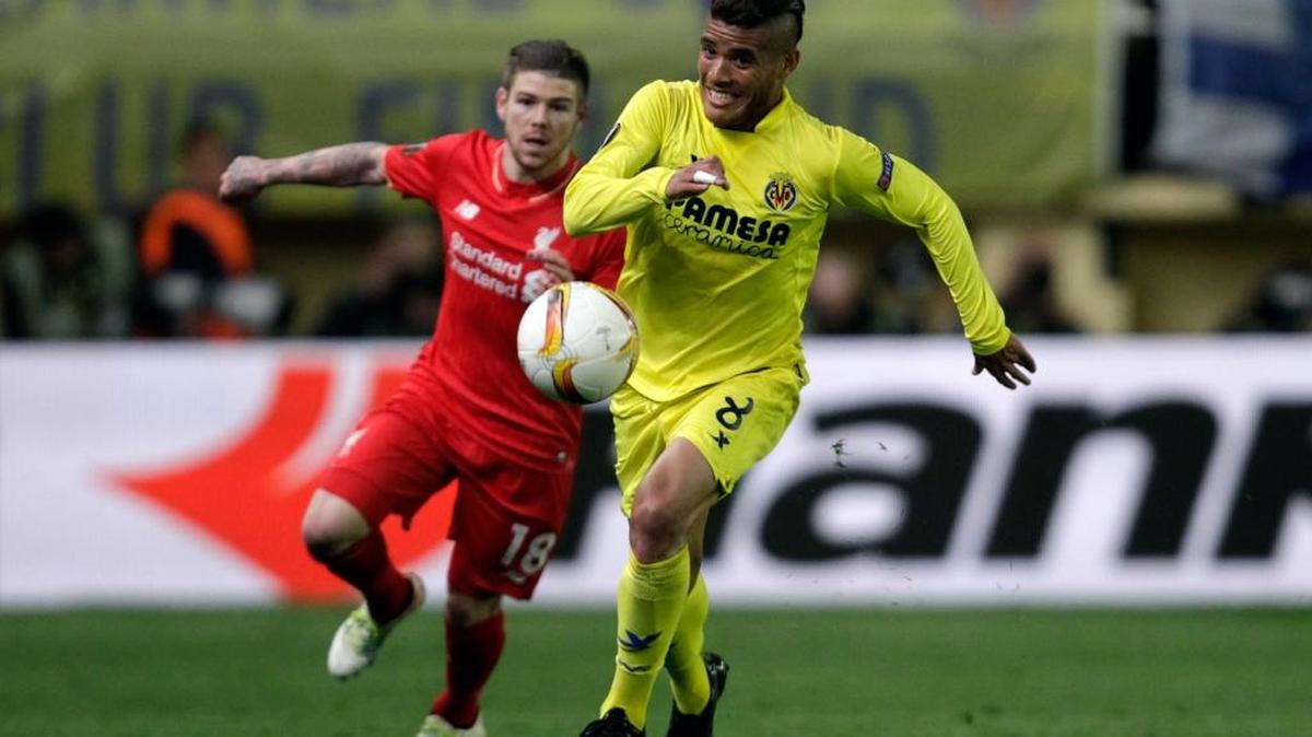 El mexicano del Villareal Jonathan dos Santos conduce el balón perseguido por el español del Liverpools Alberto Moreno.