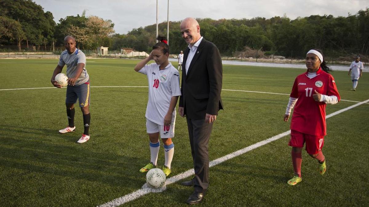 El presidente de la FIFA Gianni Infantino se prepara para hacer el saque de honor en la nueva cancha sintética del estadio La Polar en un partido de exhibición entre jugadoras del equipo nacional femenino de fútbol.