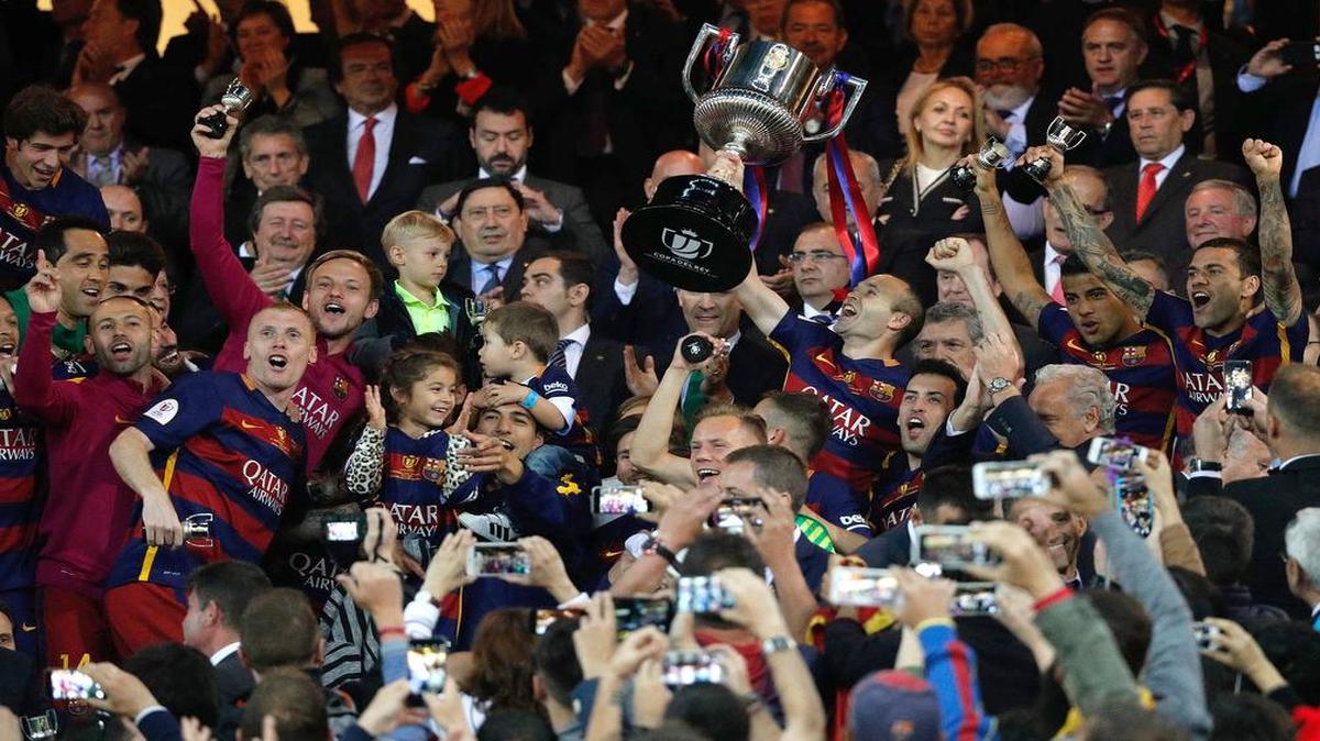 El capitán del FC Barcelona, Andrés Iniesta, levanta el trofeo junto a sus compañeros tras vencer al Sevilla en la final de la Copa del Rey disputada el domingo 22 de mayo del 2016 en el estadio Vicente Calderón, en Madrid.