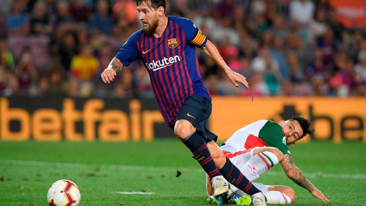 El argentino Lionel Messi (izq.), quien deja en el suelo al chileno del Alavés Guillermo Maripan, estrenó su capitanía con el Barcelona con dos goles y un partidazo.