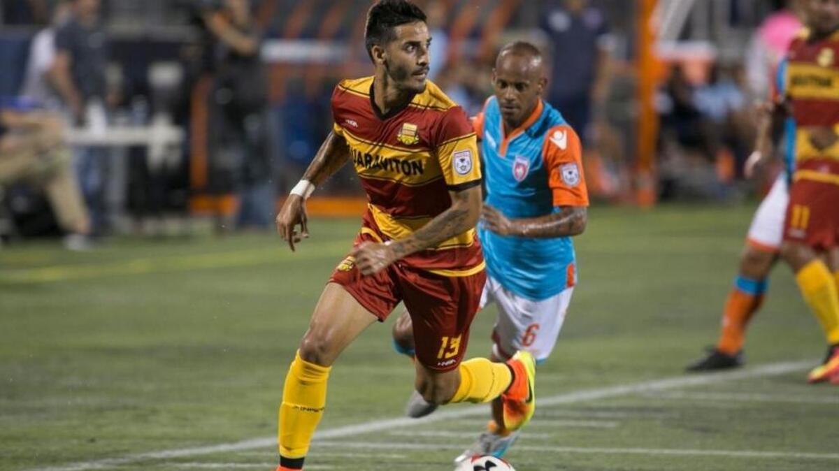 El lateral cubano Jorge Luis Corralles, de los Strikers de Fort lauderdale, controla la bola seguido por su compatriota Ariel Martínez, del Miami FC, en el partido por la NASL en el FIU Stadium, la noche del sábado 13 de agosto del 2016, en Miami.