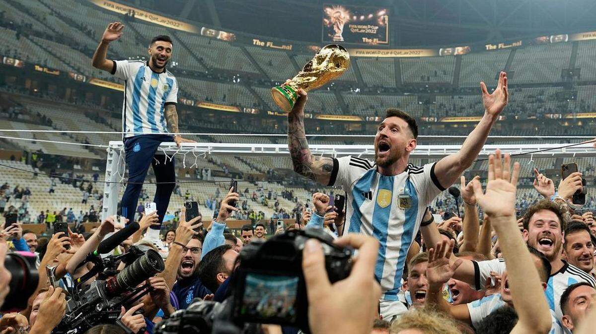 Argentina’s Lionel Messi celebrates with the trophy in front of the fans after winning the World Cup final soccer match between Argentina and France at the Lusail Stadium in Lusail, Qatar, Sunday, Dec. 18, 2022. Argentina won 4-2 in a penalty shootout after the match ended tied 3-3. (AP Photo/Martin Meissner)