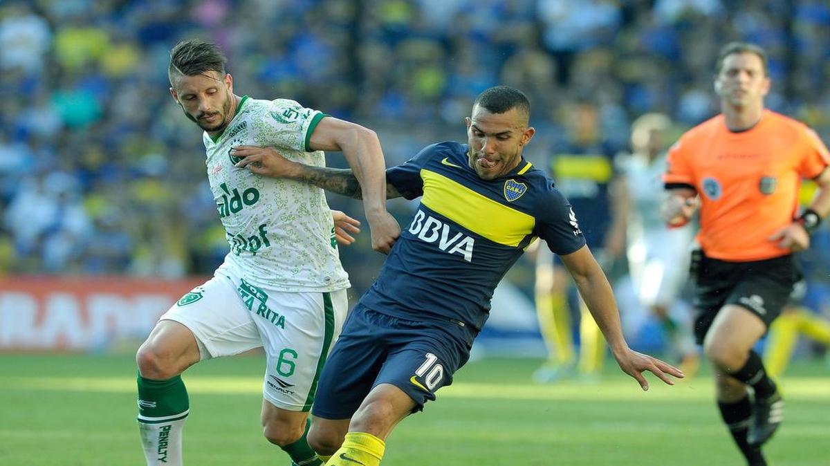 El jugador de Boca Juniors Carlos Tevez (der.) conduce la pelota ante la marca de Guillermo Cosaro, de Sarmiento, en el partido efectuado el domingo 16 de octubre del 2016, en el estadio La Bombonera de Buenos Aires.