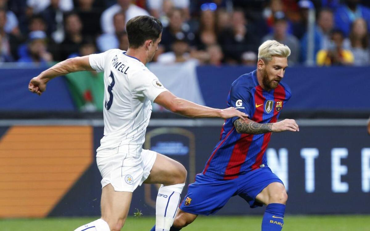 El astro del Barcelona Lionel Messi saca a pesar al defensor del Leicester City Ben Chilwell.
