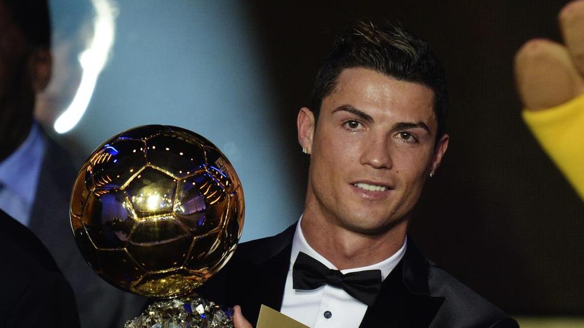 Cristiano Ronaldo levanta el Balón de Oro que ganó en el 2013, en una ceremonia celebrada el 13 de enero de ese año en Zurich, Suiza.