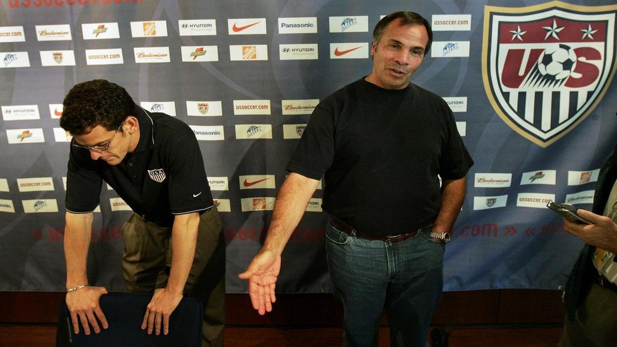Bruce Arena (der.) habla con los periodistas luego que la selección de EEUU fuera eliminada del Mundial de Alemania. El jefe de prensa Michael Kammarman escucha, en Hamburgo, el 23 de junio del 2016.