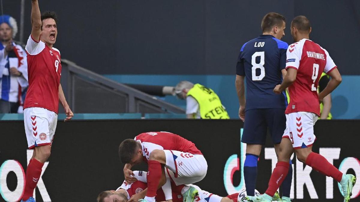 Los jugadores de Dinamarca corren hacia el danés Christian Eriksen caído al suelo durante el partido del grupo B del campeonato de fútbol de la Eurocopa 2020 entre Dinamarca y Finlandia en el estadio Parken de Copenhague, el sábado 12 de junio de 2021.