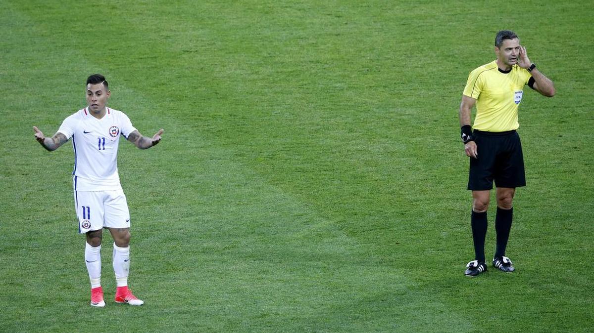 El chileno Eduardo Vargas (izq.) espera para ver si el ábitro Damir Skomina ratifica o anula su gol contra Camerún el 18 de junio por la Copa Confederaciones.