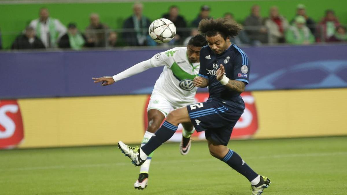 El defensa del Real Madrid Marcelo (der.) lucha por la pelota con Bruno Henrique, del Wolfsburgo, en el partido de ida de los cuartos de final de la Liga de Campeones, celebrado el miércoles 6 de abril del 2016.