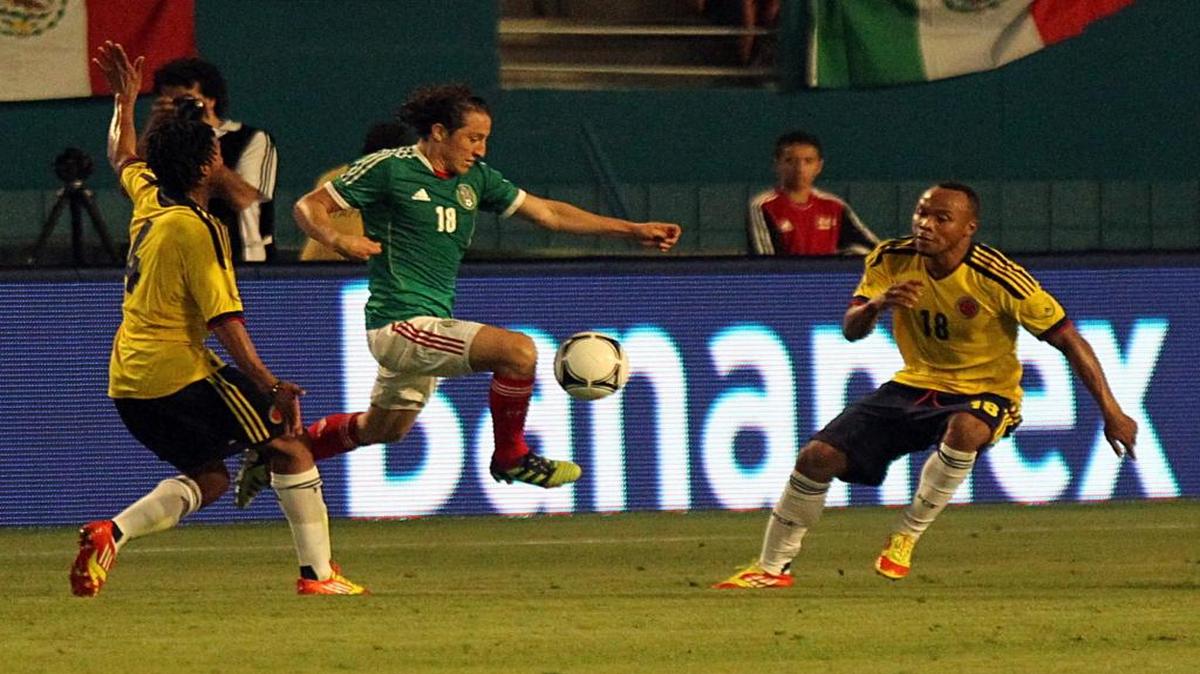 El capitán de México Andrés Guardado (centro) avanza entre Guillermo Cuadrado (izq.) y Camilo Zuniga, de Colombia el 29 de frebrero del 2012 en Miami.