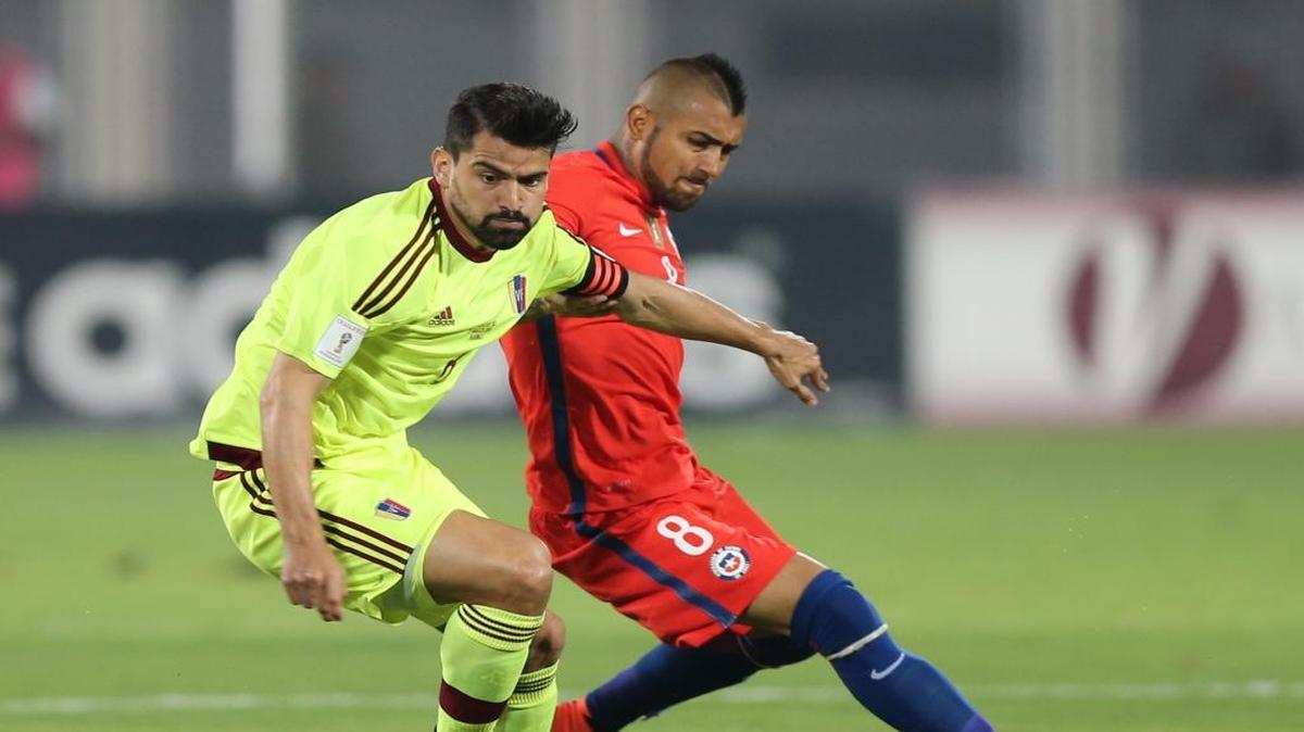 El venezolano Tomás Rincón (izq.) conduce la pelota ante la marca de Arturo Vidal, de Chile, en partido de las eliminatorias mundialistas, celebrado el 29 de marzo del 2016 en Barinas, Venezuela.