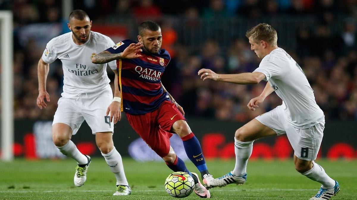 Dani Alves (centro) trata de burlar la defensa de los jugadores del Real Madrid Karim Benzema (izq.) y Toni Kroos, en el partido celebrado el 2 de abril en Barcelona.