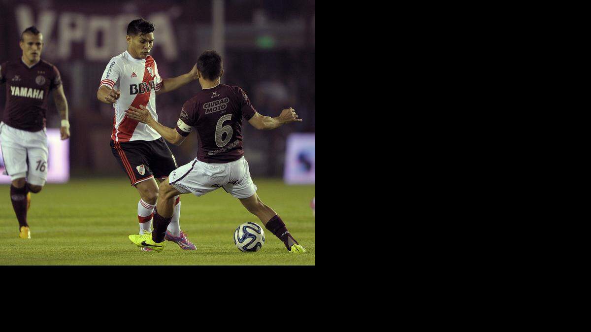 
Teofilo Gutierrez enfrenta al defensa del Lanús defender Maximiliano Velázquez (6) en el empate de River Plate, el domingo en Buenos Aires, Argentina.

