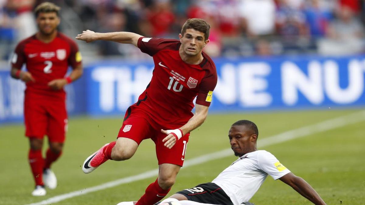 Christian Pulisic, autor de los dos goles de Estados Unidos (10), escapa de la marca del jugador de Trinidad & Tobago Kenwyne Jones, este jueves en Colorado, rumbo a Rusia 2018.