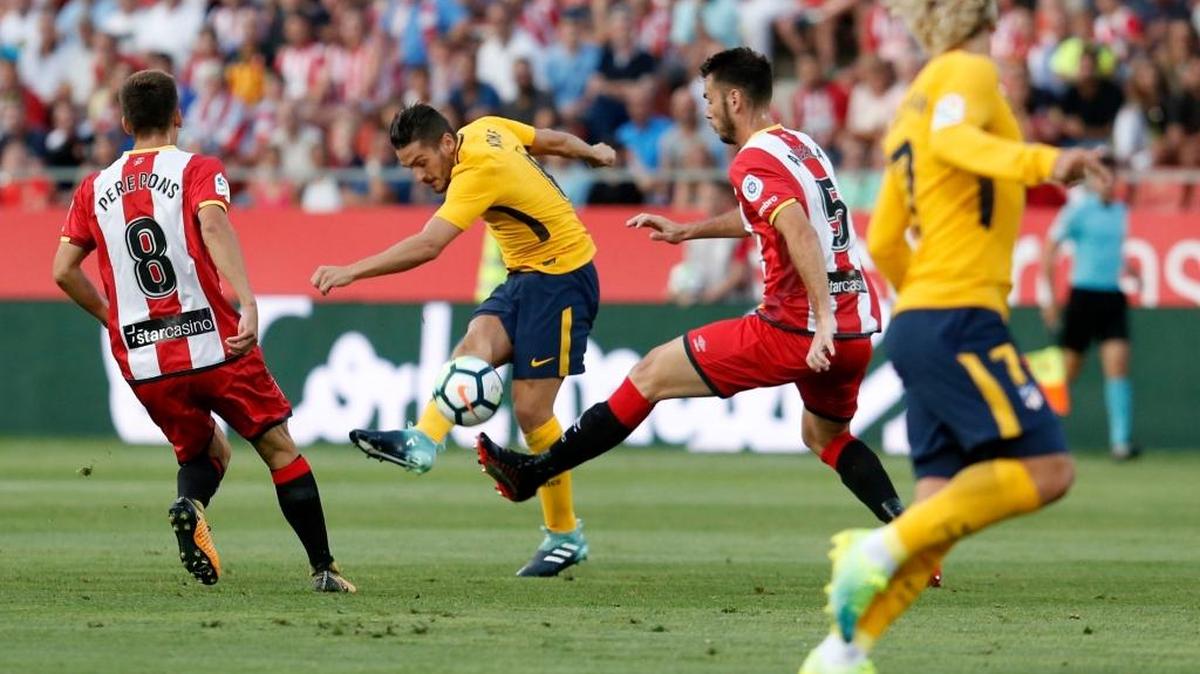 Koke, del Atlético de Madrid, dispara ante Pere Pons (izq.) y Pedro Alcalá, del Girona, el sábado en el Estadio Municipal de Montilivi, en España.