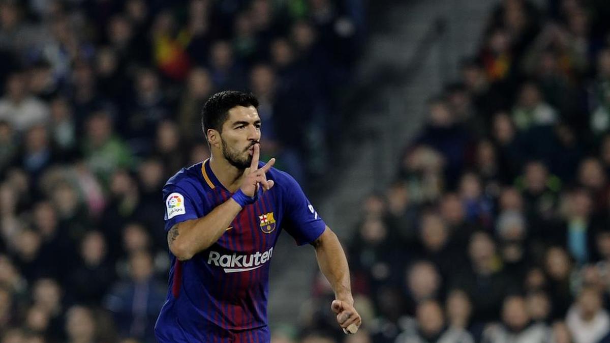 El delantero uruguayo del Barcelona Luis Suárez celebra tras anotar un gol en el partido de fútbol de la liga española entre el Real Betis y el FC Barcelona en el estadio Benito Villamarín de Sevilla el 21 de enero de 2018.
