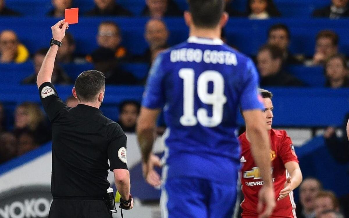 El árbitro inglés Michael Oliver (izq.) muestra la tarjeta roja al volante español del Manchester United Ander Herrera (der.), el 13 de marzo, en el partido contra el Chelsea por la FA Cup.