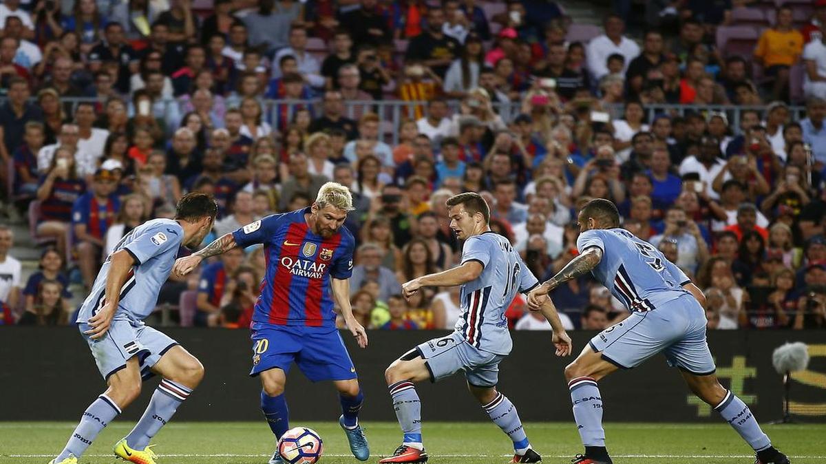 Lionel Messi, del Barcelona, es rodeado por jugadores del Sandoria dispondando el trofeo Joan Gamper .