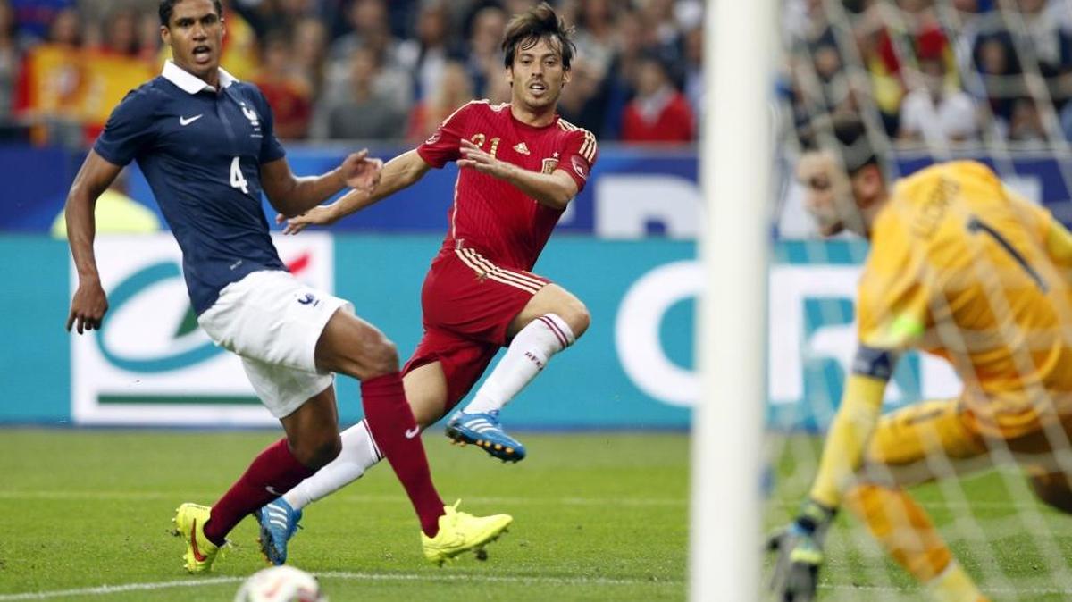 David Silva, de España, dispara sobre la marcación de Raphael Varane, de Francia, en un partido amistoso en el Stade de France en Saint Denis, en las afueras de París, el jueves 4 de septiembre del 2014.
