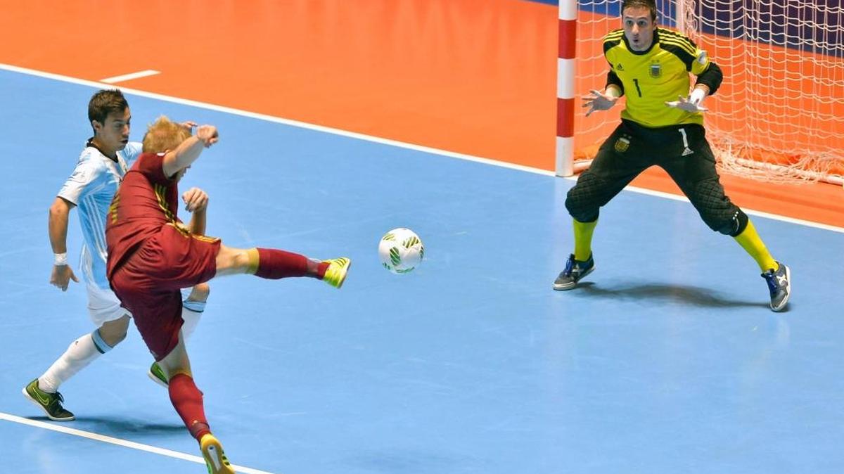 El jugador ruso Sergey Abramov (c) remata a la portería argentina defendida por Nicolas Sarmiento (der.) en el Mundial de Futsal celebrado en Colombia.