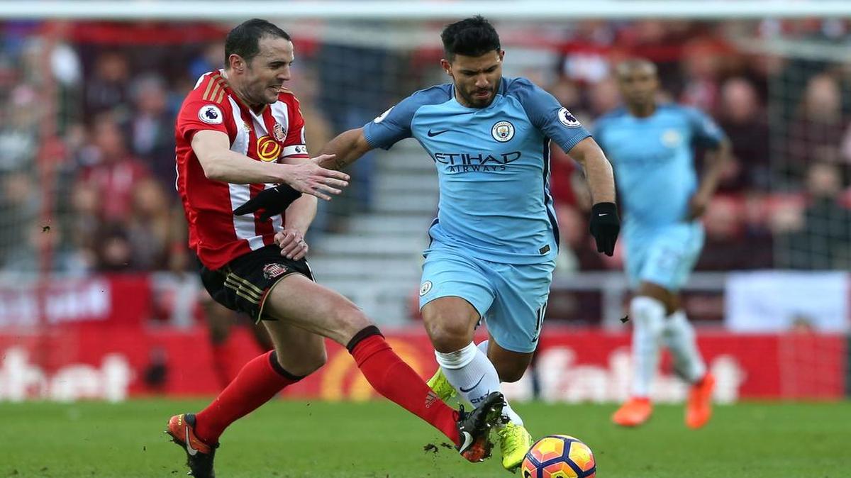 El delantero del Manchester City Sergio Agüero (der.) lucha por la pelota con John O'Shea, del Sunderland, en el partido celebrado el domingo 5 de marzo del 2017.