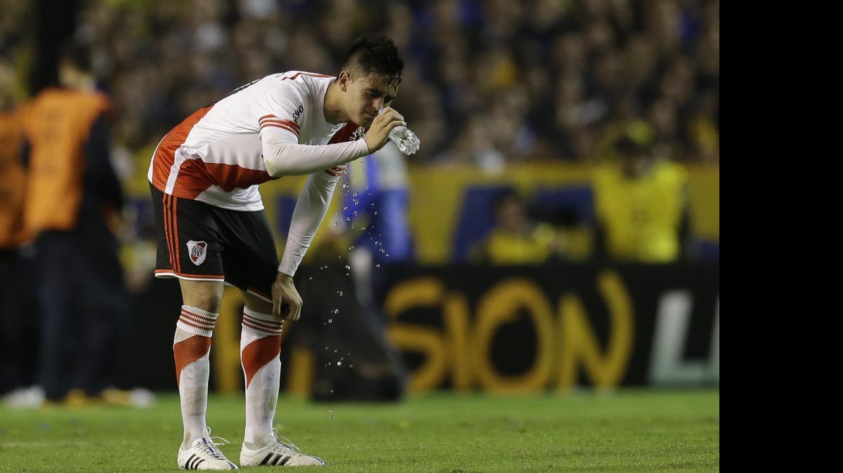 
Gonzalo Martínez, de River Plate, se enjuaga la cara con agua tras los ataques con gases tóxicos sufridos en el partido contra Boca Juniors en La Bombonera, en Buenos Aires, el jueves 14 de mayo del 2015.
