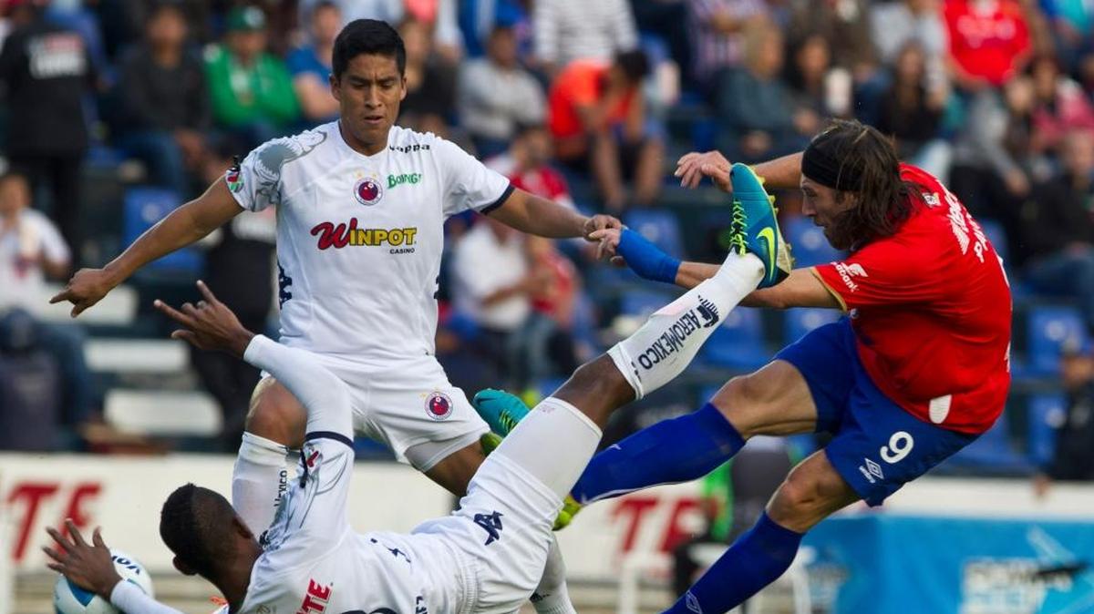 Hugo Pavone (der.), de Cruz Azul, remata sobre la marcación de Leiton Jiménez y Adrian Cortes, de Veracruz, en Ciudad de México, el sábado 25 de enero del 2014.