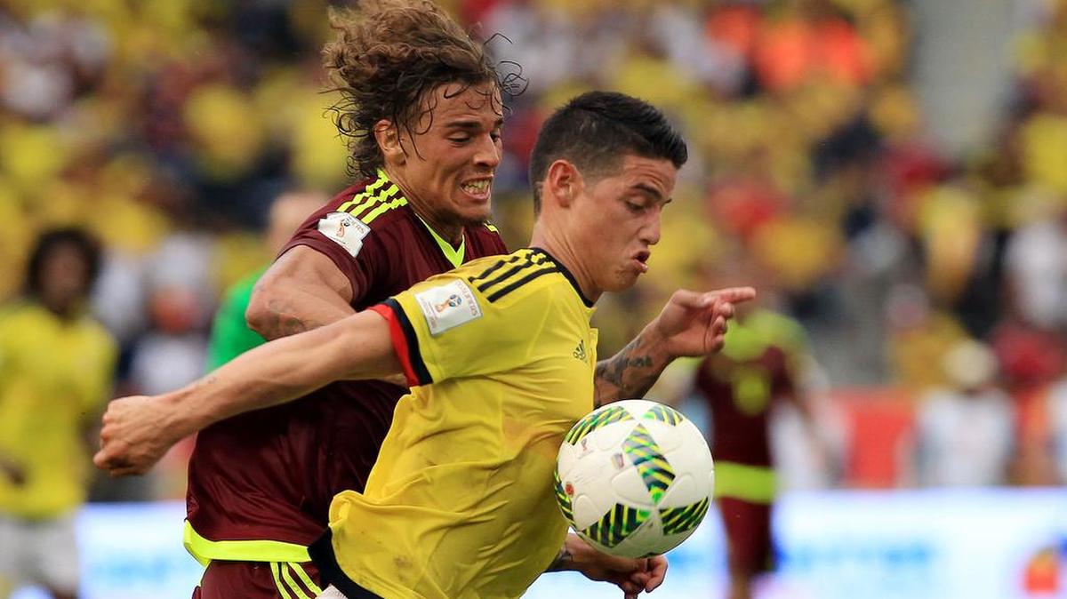 James Rodríguez (d) de Colombia disputa el balón ante Rolf Feltscher (i) de Venezuela hoy, jueves 1 de septiembre de 2016, durante el partido entre Colombia y Venezuela por las eliminatorias Rusia 2018, el estadio Metropolitano de Barranquilla (Colombia). Colombia ganó 2-0.