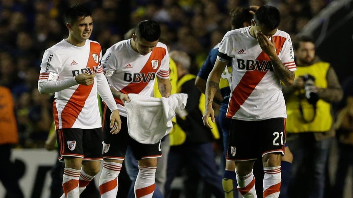 
Tres jugadores de River Plate tratan de recuperarse tras sufrir una agresión con gas pimienta por parte de de hinchas de Boca Juniors, el jueves 14 de mayo del 2015.
