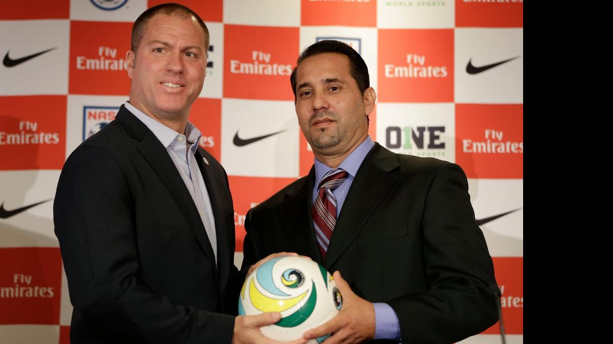 
El entrenador de la selección cubana de fútbol Wálter Benítez (der.) posa con el técnico del Cosmos de Nueva York, Giovanni Savarese, en una conferencia de prensa el 16 de marzo del 2015 en Nueva York.
