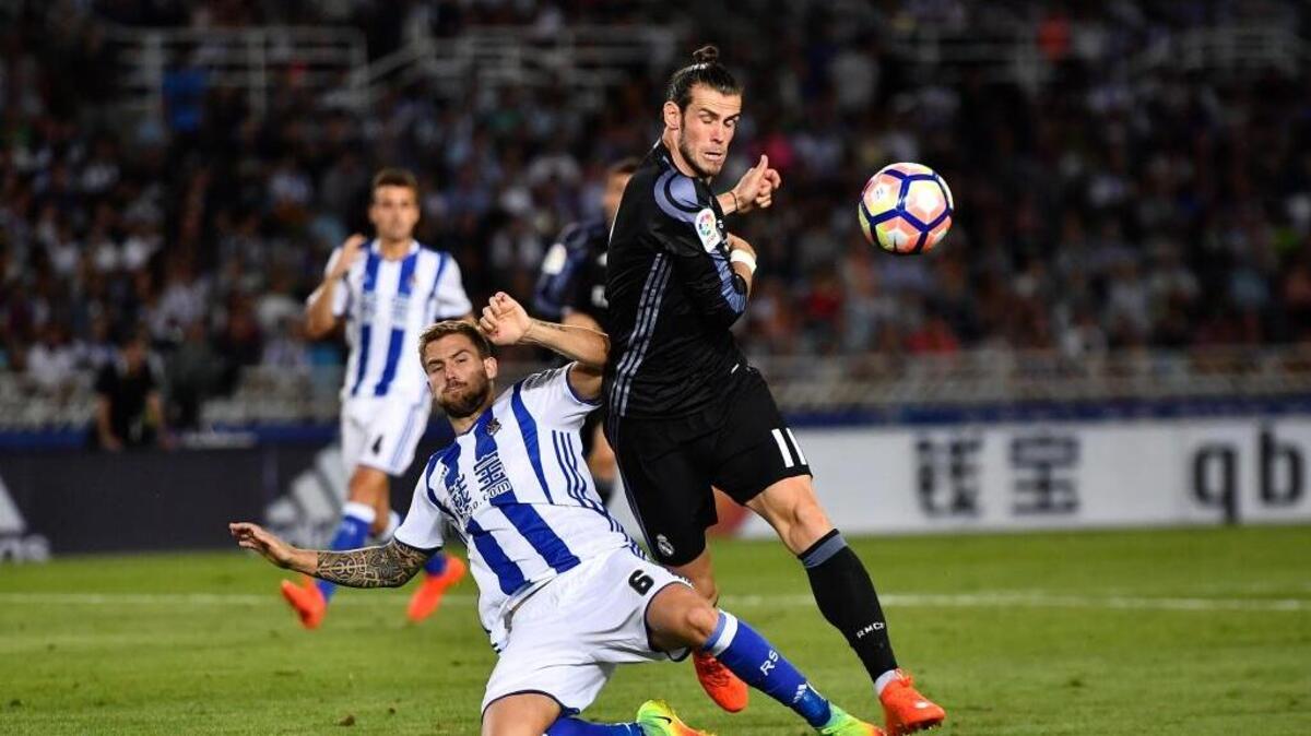 El jugador del Real Madrid Gareth Bale (der.) lucha por la pelota con Iñigo Martínez, de la Real Sociedad, en el partido efectaudo el 21 de agosto del 2016 en San Sebastián, España.