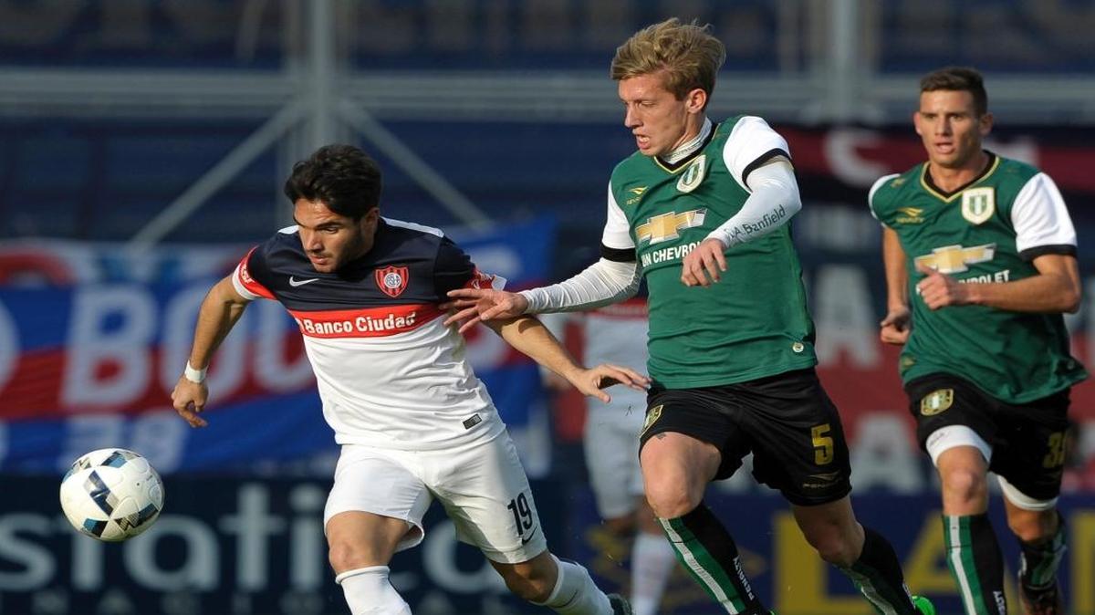 El delantero de San Lorenzo Ezequiel Cerutti (L) pugna por el balón con el volante de Banfield Ivan Rossi.
