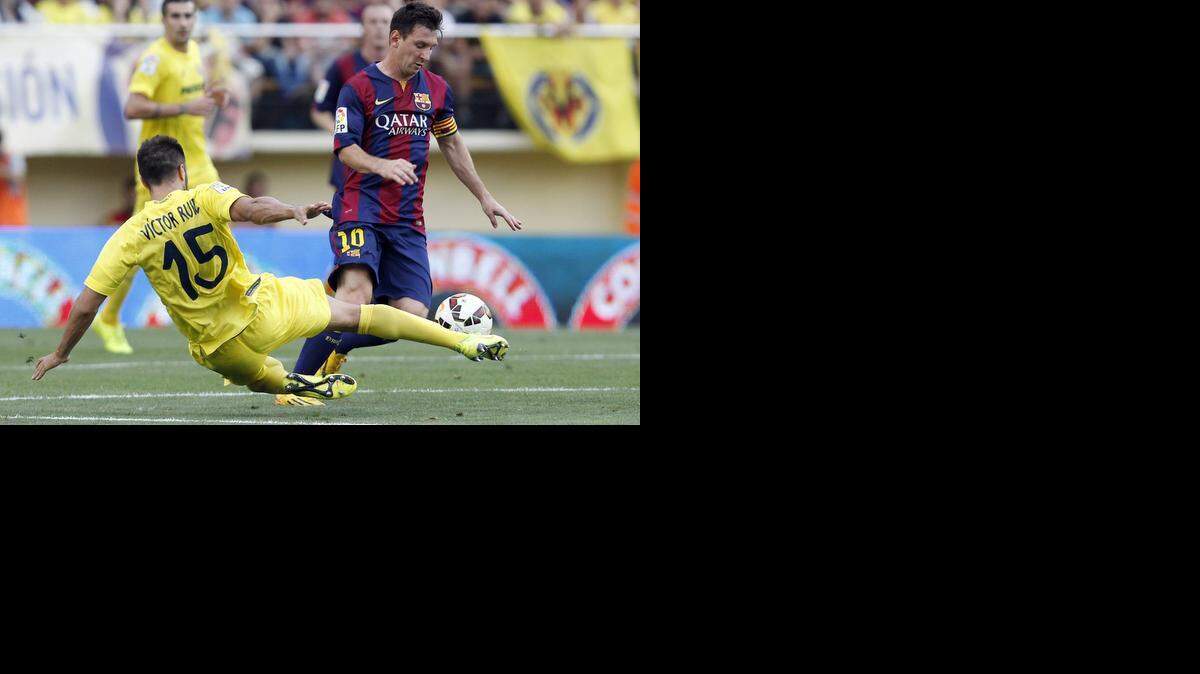 
 Lionel Messi (der.) trata de evadir al jugador de Villarreal Víctor Ruiz, en el partido de la liga española celebrado el 31 de agosto.


