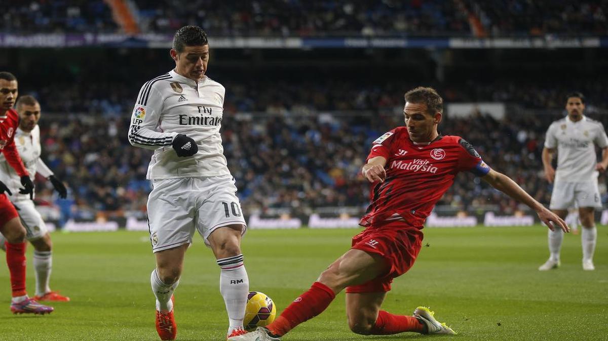 James Rodríguez (izq.) conduce la pelota ante la marca de Fernando Navarro, en un partido entre el Real Madrid y el Sevilla, el 4 de febrero del 2015 en la liga española.
