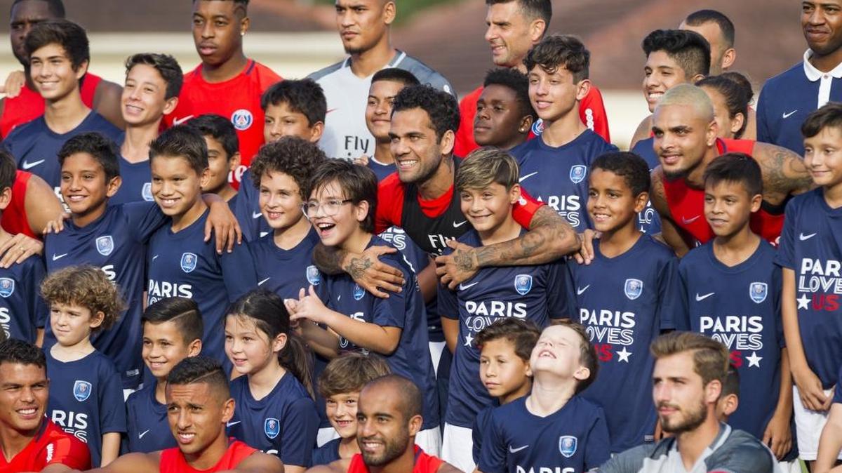 Dani Alves abraza a dos jugadores de la academia de fútbol del club en la práctica del Paris Saint-Germain en Barry University, la tarde del domingo 16 de julio del 2017.