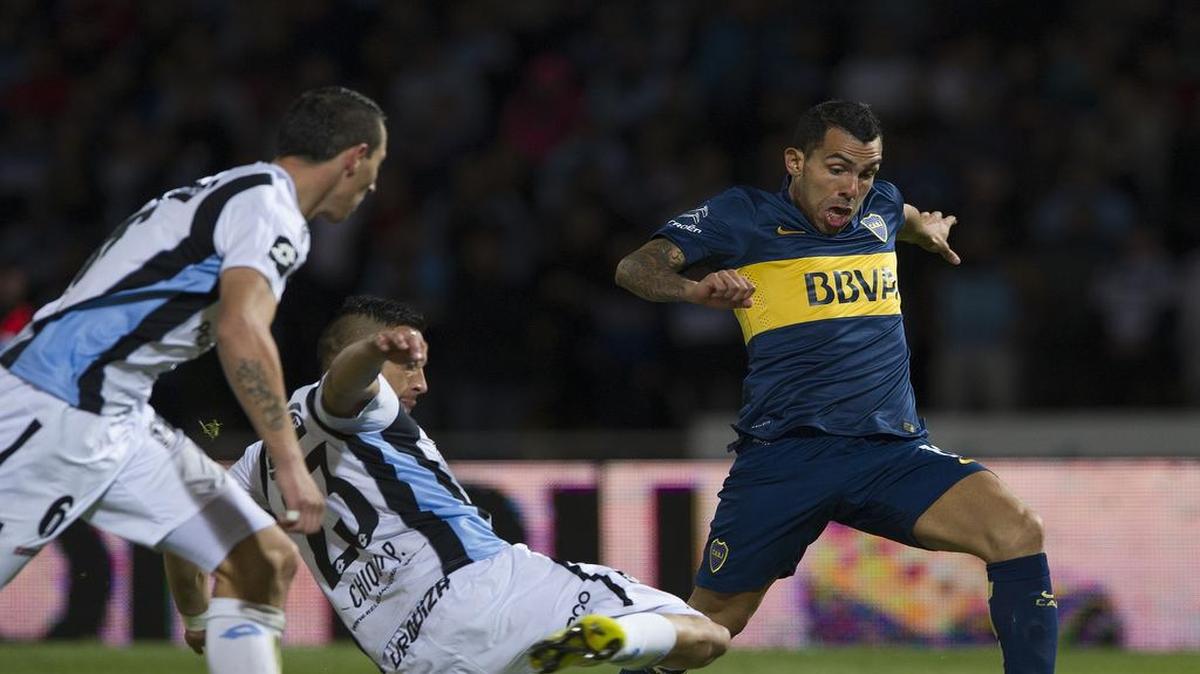 
El delantero de Boca Juniors, Carlos Tevez (der.) elude a dos jugadores de Belgrano de Córdoba, el 30 de julio del 2015 en el torneo argentino.
