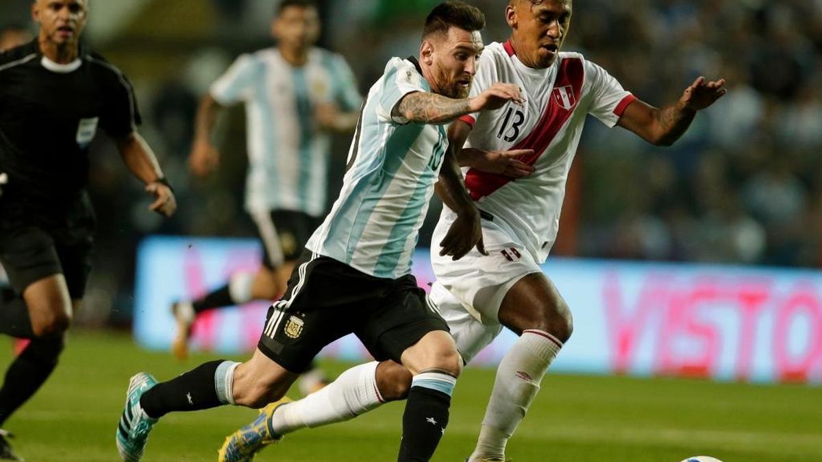 Lionel Messi (izq.), de Argentina, se lleva la pelota marcado por Renato Tapia, de Perú, en la Bombonera, en Buenos Aires, Argentina, la noche del jueves 5 de octubre del 2017.