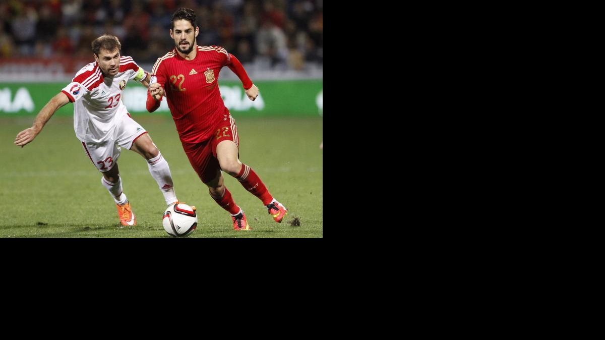 
 El volante de la selección española, Isco (d), se lleva el balón ante el jugador de la selección de Bielorrusia, Kalachev.



