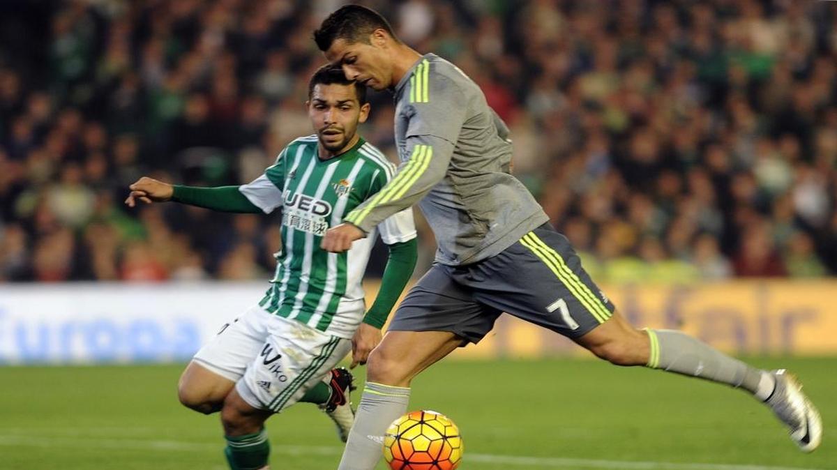 Cristiano Ronaldo, del Real Madrid (der.), dispara a puerta ante el zaguero del Betis Molinero.