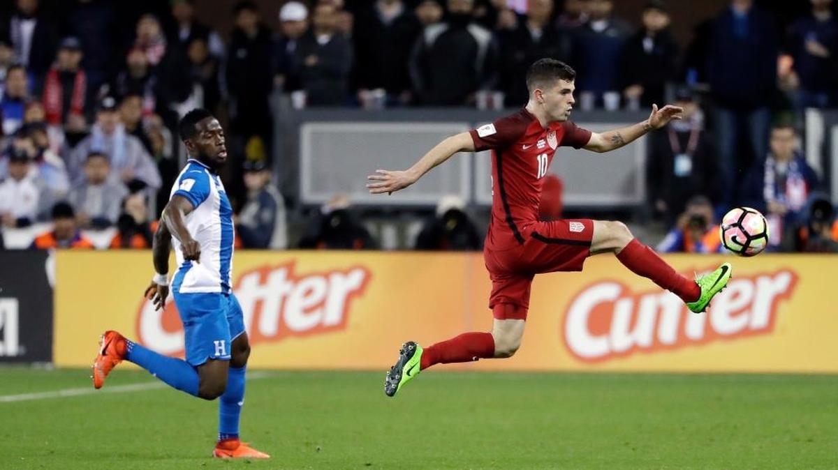Christian Pulisic, de EEUU (der.),controla un balón ante un defensa de Honduras.