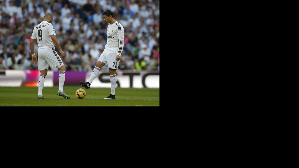 
Los delanteros del Real Madrid Cristiano Ronaldo (der.) y Karim Benzema tocan la bola en el choque del sábado.


