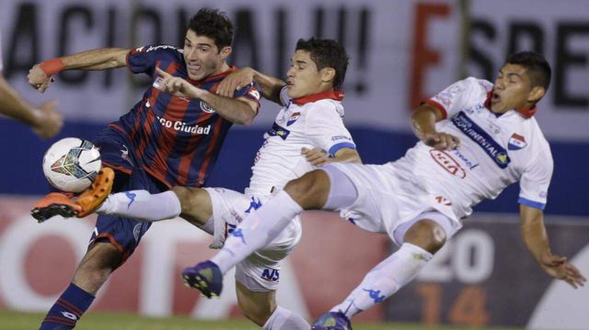 
El jugador de San Lorenzo Ignacio Piatti (izq.) conduce la pelota la marca de Juan Argüello (centro) y Angel Almiron, del Nacional de Paraguay, en la final de la Copa Libertadores el 6 de agosto en Asunción, Paraguay.


