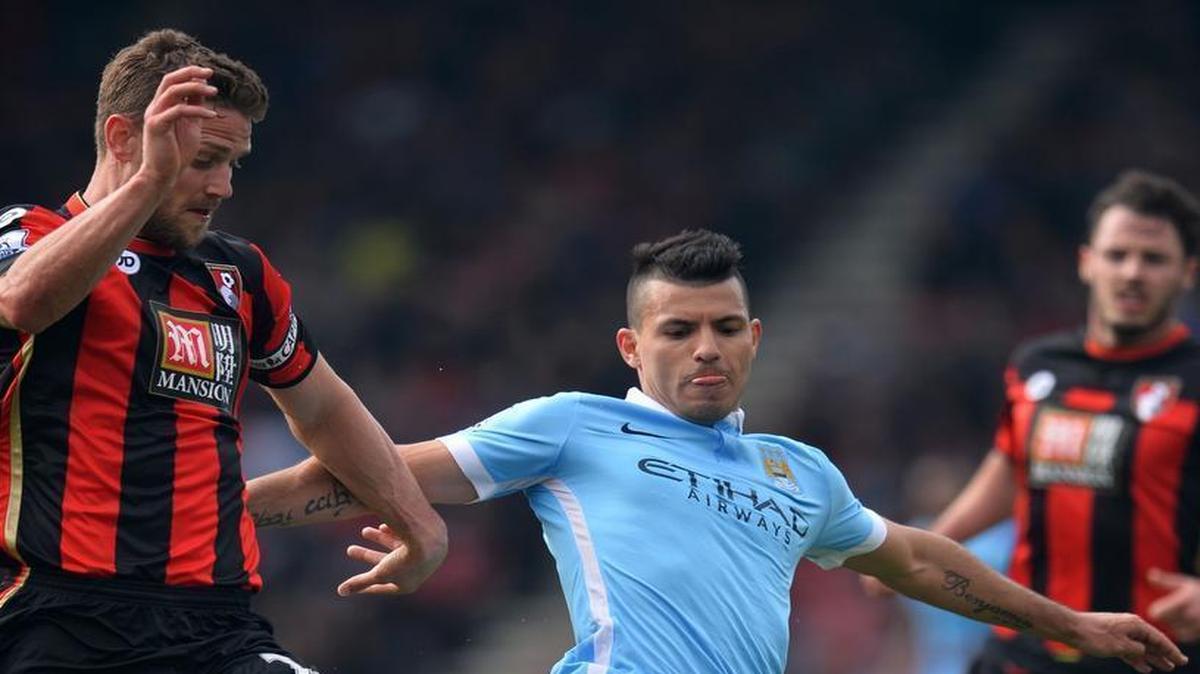 El delantero argentino del Manchester City Sergio Agüero (centro) lucha por el balón con Simon Francis, del Bournemouth (izq.), durante un partido de la liga inglesa,  celebrado el 2 de abril de 2016. 
