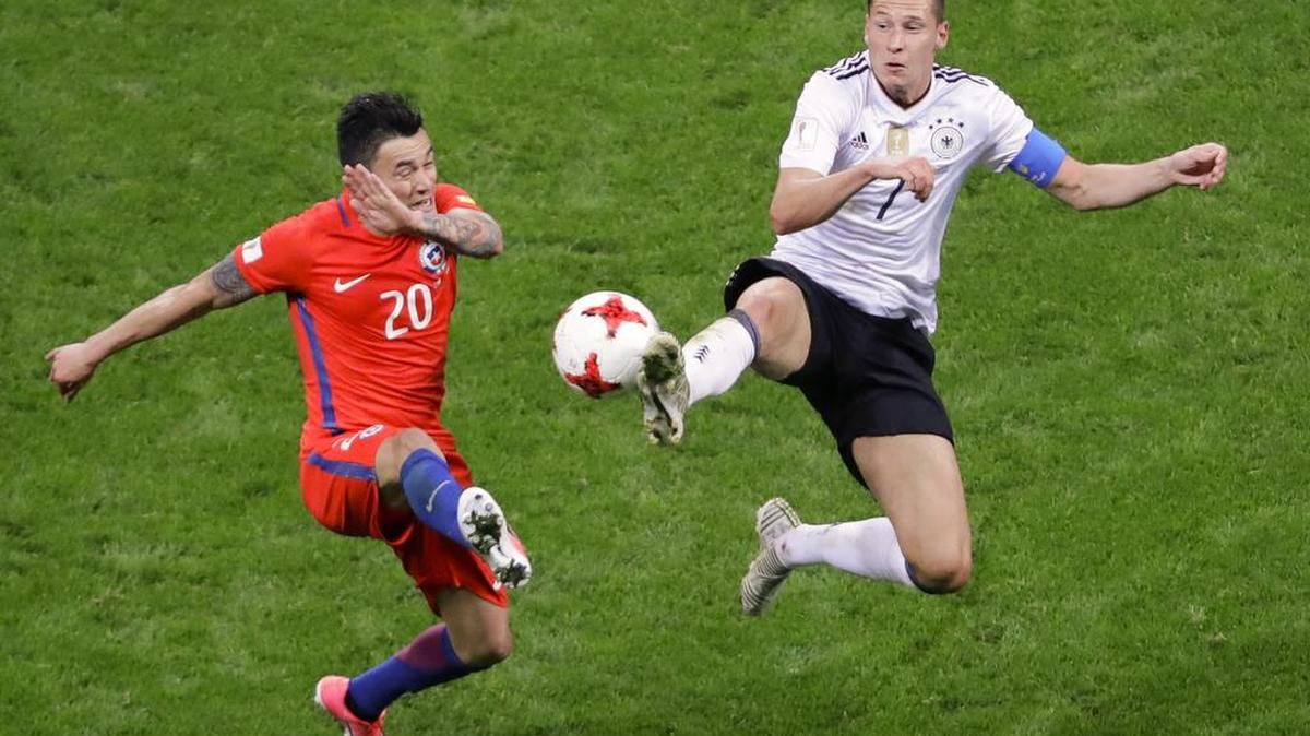 El capitán de Alemania Julian Draxler pugna por el balón con Charles Aranguiz, de Chile (izq.), en el empate 1-1 entre ambas selecciones el 22 de junio en la fase de grupo de la Copa Confederaciones.