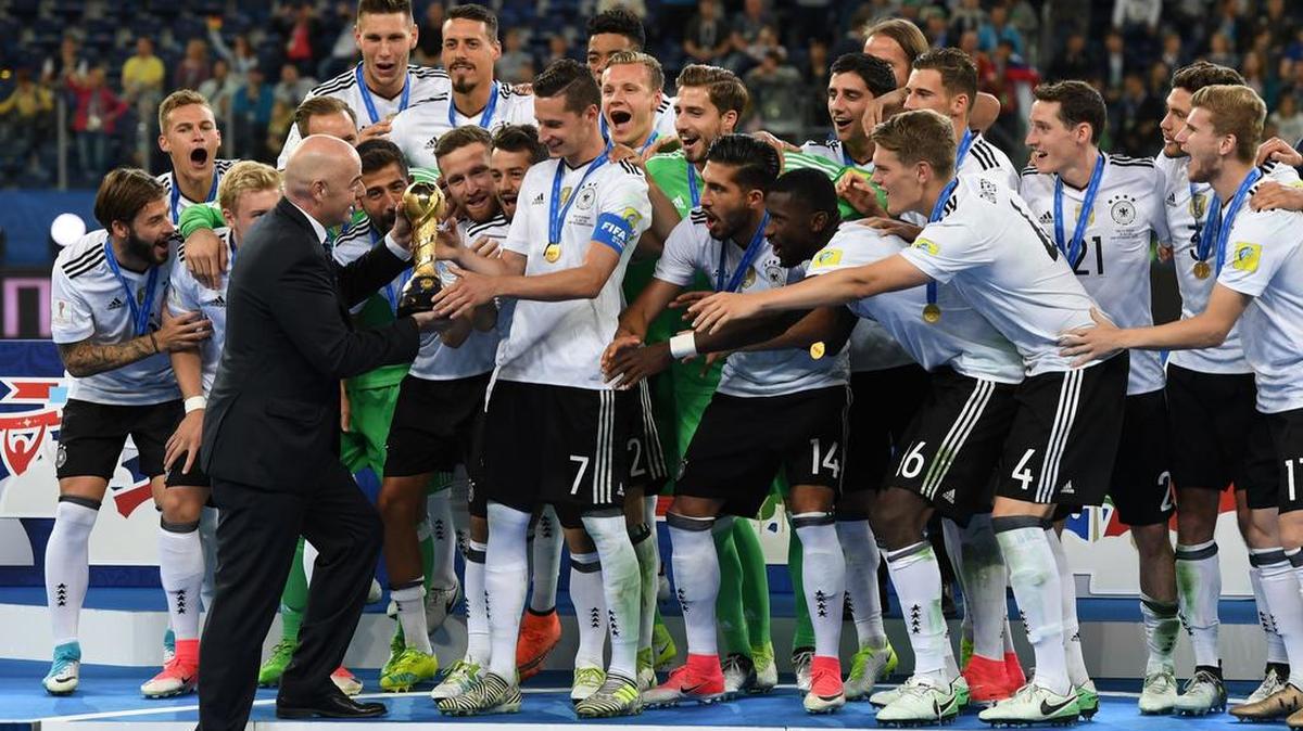 El presidente de la FIFA, Gianni Infantion, entrega el trofeo al mediocampista alemán Julian Draxler después de que Alemania ganara el partido de fútbol de la Copa de las Confederaciones 2017 entre Chile y Alemania en el Estadio de San Petersburgo el 2 de julio de 2017.