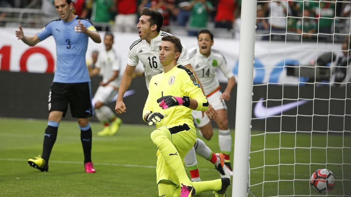 Héctor Herrera (16) y Javier Hernández (14) celebran entre el portero de Uruguay Fernando Muslera y su zaguero Diego Godín (3) el gol que pone delante a México.