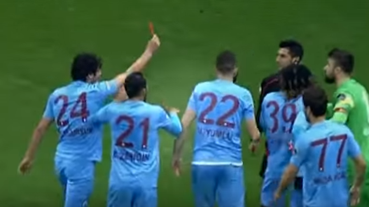 El futbolista del Trabzonspor Salih Dursun le muestra la tarjeta roja al árbitro en el partido entre Galatasaray y el Trabzonspor en la liga turca.